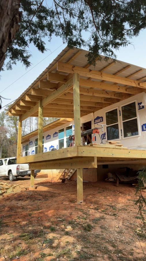 Covered porch with timber posts and beams on a new home in Lake James